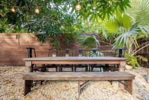 una mesa de picnic de madera y sillas en un jardín en Atelier Lumi - at lumicollection, en Miami