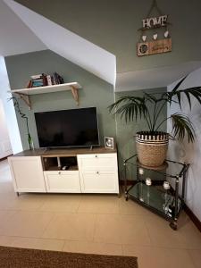 a living room with a white entertainment center with a flat screen tv at Casa Milan in Puerto Calero