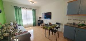 a kitchen and a living room with a table and a couch at CASA ROSY in Puerto del Rosario