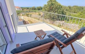 奥利布岛2 Bedroom Gorgeous Apartment In Olib的带两把椅子和一张桌子的阳台