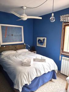 Un dormitorio azul con una cama con toallas. en Bungalow CASIOPEA Internet 300 Mb SAT SMARTTV, en El Campello 42 fotos más