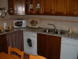 a kitchen with a sink and a washing machine at Casa Rural Cendal in Navacarros