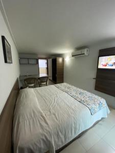 a bedroom with a bed and a flat screen tv at Blue Sunset Suites in Penha
