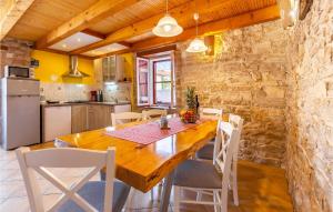 a kitchen and dining room with a wooden table and chairs at Holiday Home Kavran - 08 in Kavran