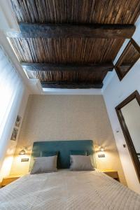a bedroom with a bed with a wooden ceiling at B & B Boutique Epoca in Salerno