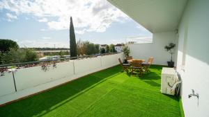 a balcony with green grass and a table and chairs at Olivar Gines 10 MINUTOS A SEVILLA in Ginés
