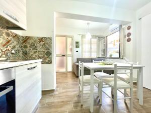 a kitchen and dining room with a table and chairs at Teddy House Apartments in Bari Sardo +28 photos