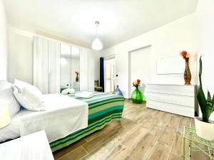 a white bedroom with a bed and a mirror at Teddy House Apartments in Bari Sardo