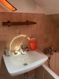 a bathroom sink with an orange container on top of it at Aradi Apartman Siófok in Siófok