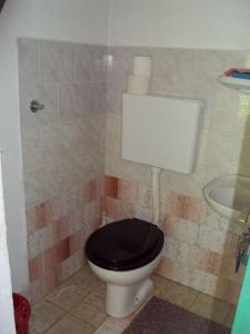 a bathroom with a toilet with a black seat and a sink at House Lidija in Postira