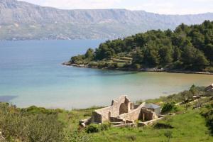 an old building on a hill next to a body of water at House Lidija in Postira