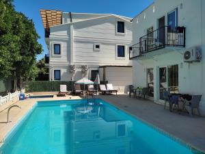 a swimming pool in front of a house at Garden Prizma Rooms&Aparts in Kemer