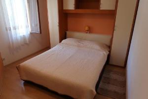 a small bed in a small room with a window at Apartments Brti in Supetar
