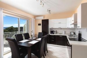a kitchen with a table and chairs and a balcony at House Jure in Sumartin