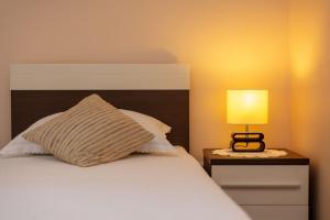 a bed with a pillow and a lamp on a night stand at House Jure in Sumartin