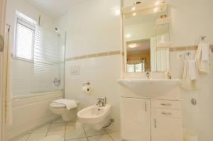 a white bathroom with a sink and a toilet at House Jure in Sumartin