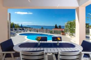 a patio with a table and chairs and a swimming pool at House Jure in Sumartin
