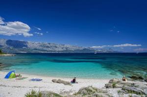 two people sitting on a beach with the blue water at House Jure in Sumartin +27 photos