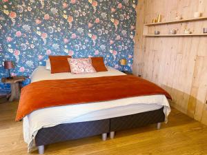 een slaapkamer met een bed met een bloemenbehang bij La Maison des Senteurs in Francorchamps