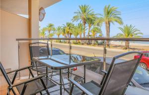 a table and chairs on a balcony with palm trees at Cozy Home In Cartagena With Kitchen in Cartagena