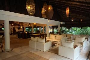 a living room with white couches and a bar at The Beach Tulum Hotel in Tulum