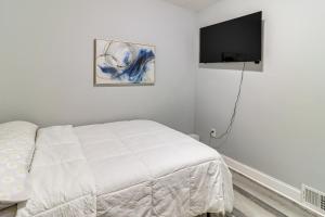 a bedroom with a bed and a flat screen tv at 4 Mi to Dtwn Detroit Townhome Near North End in Detroit