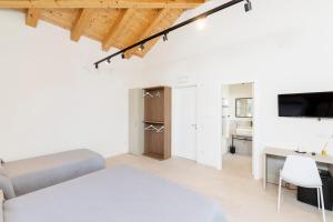 a white living room with a couch and a desk at Furrìa in Vizzini
