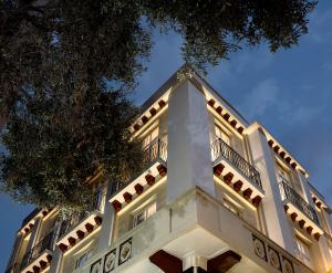 een wit gebouw met een boom ervoor bij Hipsters Hotel in Thessaloniki