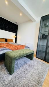 une chambre avec un lit avec une tête de lit capitonnée verte dans l'établissement Appartement 50m de la plage et toutes commodités, plein centre ville et silencieux, à La Grande Motte