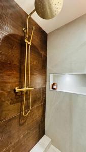 La salle de bains est pourvue d'une douche et d'un mur en bois. dans l'établissement Appartement 50m de la plage et toutes commodités, plein centre ville et silencieux, à La Grande Motte