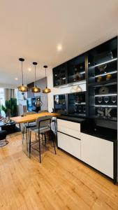 une cuisine avec une table en bois et une salle à manger dans l'établissement Appartement 50m de la plage et toutes commodités, plein centre ville et silencieux, à La Grande Motte