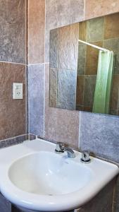 a bathroom with a sink and a mirror at Guanaco Inn in El Calafate