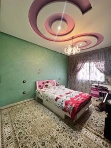 1 dormitorio con 1 cama y techo con lámpara de araña. en Dacia vue sur mer, en Tánger