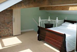 a bedroom with a bed and a brick wall at The Sewing Room in Hebden Bridge