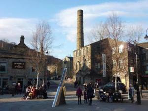 a group of people standing in front of an old factory at The Sewing Room in Hebden Bridge