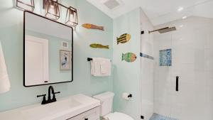 a white bathroom with a sink and a mirror at A Royal Affair by Last Key Realty in Key West +33 photos