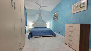 ein blaues Schlafzimmer mit einem Bett und einem Deckenventilator in der Unterkunft Villa Marina in Orosei + 46 Fotos
