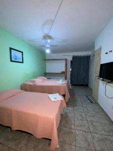a room with two beds and a flat screen tv at Minas Hotel in Alcobaça