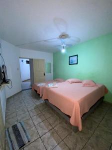 a bedroom with a bed with pink sheets and a green wall at Minas Hotel in Alcobaça
