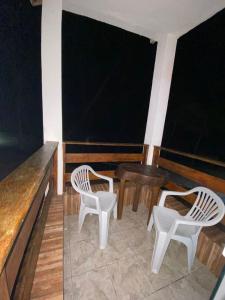 two white chairs and a table in a room at Minas Hotel in Alcobaça
