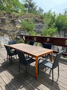 a wooden table and chairs on a deck at Apartmán typu Loft in Hořovičky