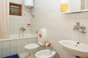 un bagno con un water bianco e un lavandino di Apartments Penović a Prižba Altre 9 foto