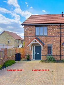 una casa de ladrillo con una plaza de aparcamiento delante de ella en Luxury 2 Bed - FREE Private Parking - Contractors, en Newcastle
