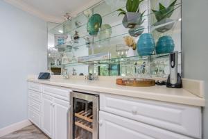 a kitchen with glass shelves and a counter with vases at Phoenix on the Bay 1215 condo in Orange Beach