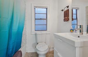 a bathroom with a toilet and a sink and a window at Cute 1bed 1bath walk to French Q and Bourbon St in New Orleans