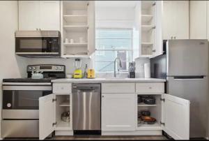 a kitchen with white cabinets and stainless steel appliances at Cute 1bed 1bath walk to French Q and Bourbon St in New Orleans