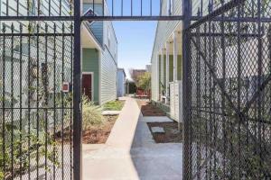 a chain link fence with a walkway between two buildings at Cute 1bed 1bath walk to French Q and Bourbon St in New Orleans