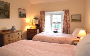 A bed or beds in a room at Inverawe Cottages