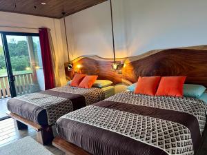 une chambre d'hôtel avec deux lits et un balcon dans l'établissement Monteverde Ecolove, à Monteverde Costa Rica