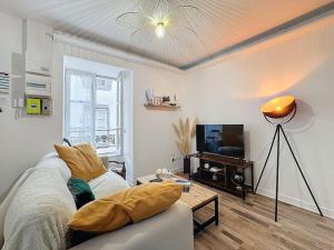 クレルモン・フェランにあるCharmant appartement Montferrand 5 persのソファとテレビのあるリビングルーム